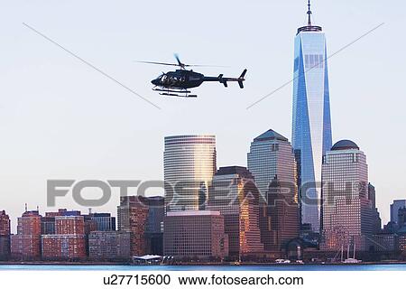 Stock Image - Helicopter flying over city. Fotosearch