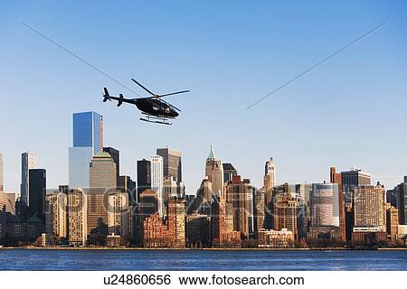 Helicopter flying over city View Large Photo Image Stock Photograph - Helicopter flying over city. Fotosearch