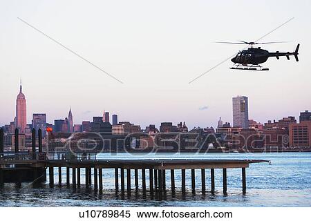 Helicopter flying over city View Large Photo Image Stock Photography - Helicopter flying over city. Fotosearch