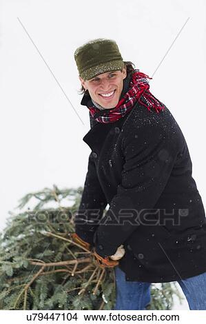 Man carrying Christmas tree View Large Photo Image Picture - Man carrying Christmas tree. Fotosearch