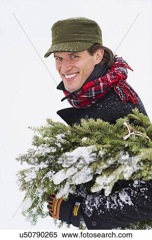 Man carrying Christmas tree View Large Photo Image Stock Photography - Man carrying Christmas tree. Fotosearch