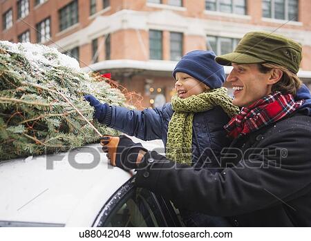 Stock Photo - Man with kid (6-7) bonding Christmas tree. Fotosearch