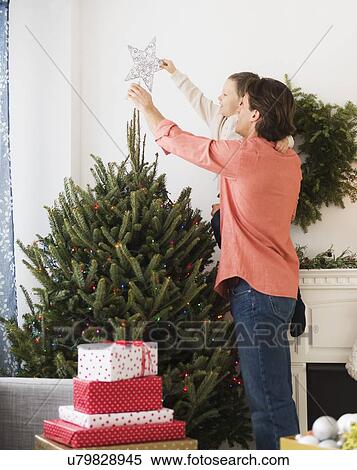 Man with kid (6-7) decorating Christmas tree View Large Photo Image Stock Photography - Man with kid (6-7) decorating Christmas tree. Fotosearch