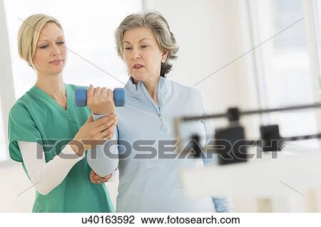 Mature woman exercising with personal trainer View Large Photo Image Stock Image - Mature woman exercising with personal trainer. Fotosearch