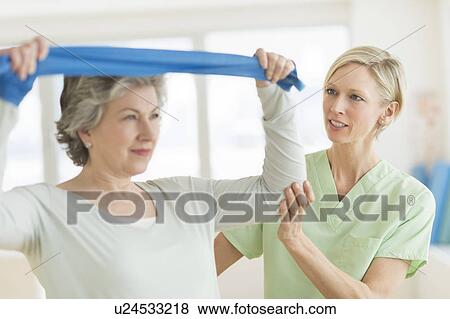 Mature woman exercising with personal trainer View Large Photo Image Stock Photo - Mature woman exercising with personal trainer. Fotosearch