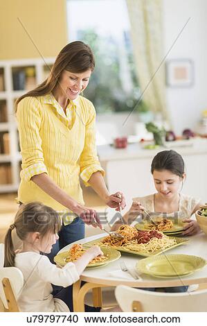 Mother and daughters (4-5, 8-9) eating pasta View Large Photo Image Stock Image - Mother and daughters (4-5, 8-9) eating pasta. Fotosearch