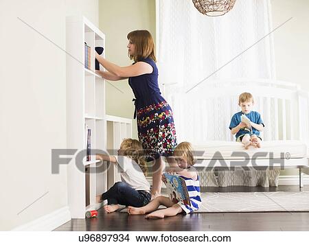 Picture - Mother with son (8-9) and daughters (4-5, 6-7) in their room. Fotosearch