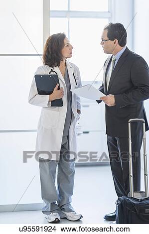 Picture - Pharmaceutical representative talking to female doctor. Fotosearch