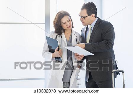 Stock Photo - Pharmaceutical representative talking to female doctor. Fotosearch