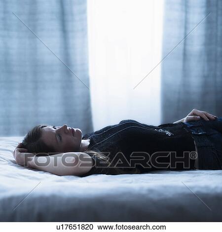 Portrait of beautiful woman lying down on bed View Large Photo Image Stock Image - Portrait of beautiful woman lying down on bed. Fotosearch