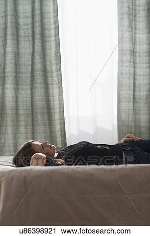 Portrait of beautiful woman lying down on bed View Large Photo Image Stock Image - Portrait of beautiful woman lying down on bed. Fotosearch