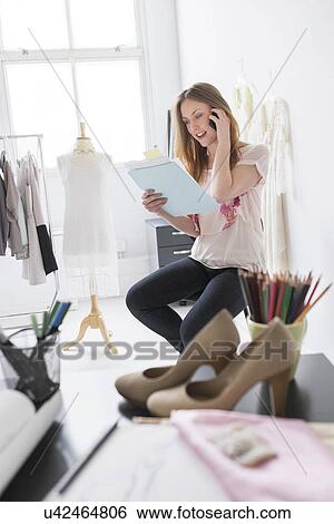Stock Photograph - Portrait of female costume designer using mobile phone in studio. Fotosearch