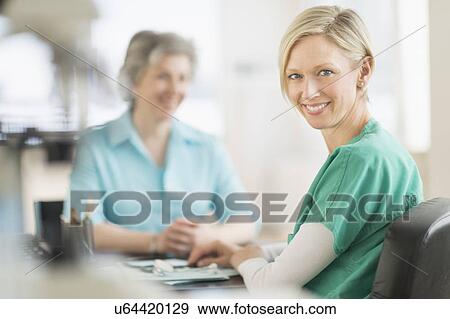 Portrait of female doctor, patient in background View Large Photo Image Stock Photo - Portrait of female doctor, patient in background. Fotosearch