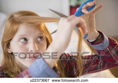 Portrait of girl (12-13) cutting her hair View Large Photo Image Stock Photo - Portrait of girl (12-13) cutting her hair. Fotosearch