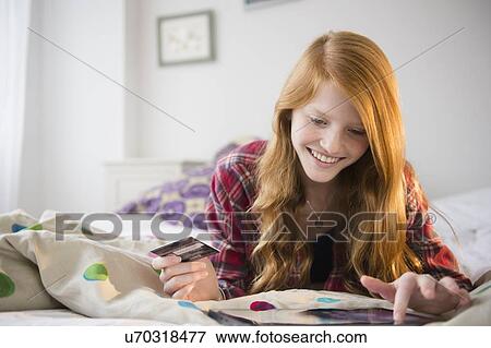 Stock Photo - Portrait of girl (12-13) doing on-line shopping. Fotosearch