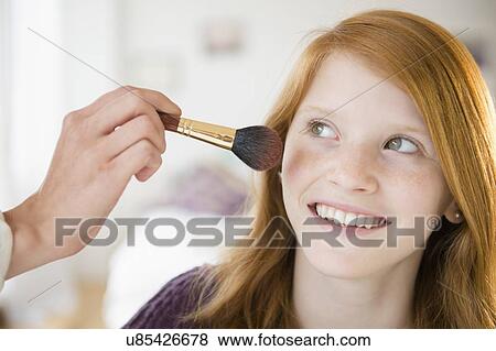 Stock Photo - Portrait of girl (12-13) getting make-up. Fotosearch