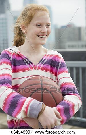 Stock Photo - Portrait of girl (12-13) holding ball. Fotosearch