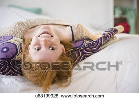 Portrait of girl (12-13) lying on bed View Large Photo Image Stock Photo - Portrait of girl (12-13) lying on bed. Fotosearch