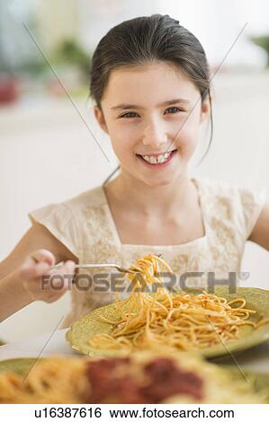 Portrait of girl (8-9) eating pasta View Large Photo Image Stock Photograph - Portrait of girl (8-9) eating pasta. Fotosearch