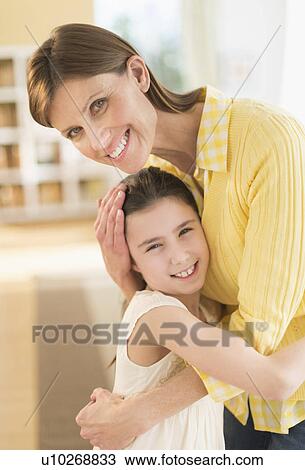 Stock Image - Portrait of mother and daughter (8-9) hugging. Fotosearch