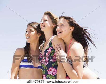 Stock Photograph - Portrait of three women on beach. Fotosearch