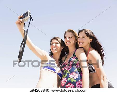 Portrait of three women photographing themselves View Large Photo Image Stock Image - Portrait of three women photographing themselves. Fotosearch