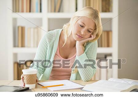 Stock Photo - Portrait of tired female student in library. Fotosearch