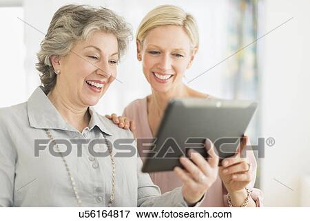 Portrait of two women using digital tablet View Large Photo Image Stock Photo - Portrait of two women using digital tablet. Fotosearch