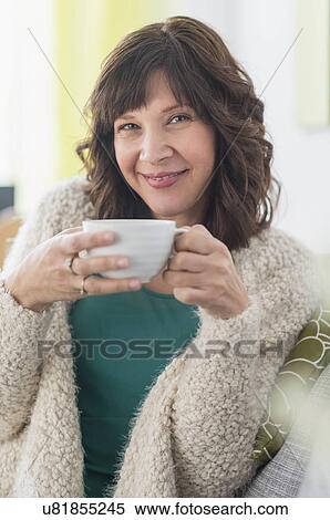 Stock Photography - Portrait of woman holding hot drink. Fotosearch