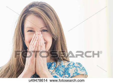 Picture - Portrait of woman laughing, hands on face. Fotosearch