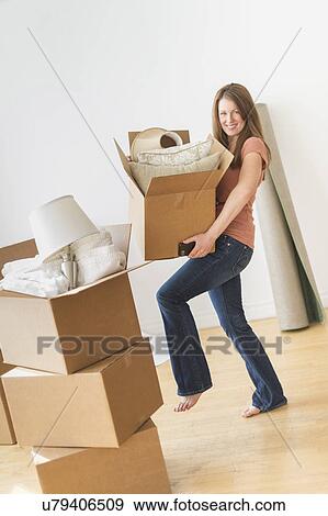 Stock Photo - Portrait of woman moving in to new house. Fotosearch