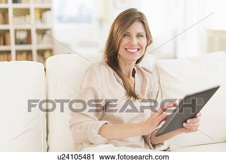 Stock Image - Portrait of woman using tablet pc. Fotosearch