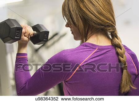 Stock Image - Portrait of woman weightlifting. Fotosearch