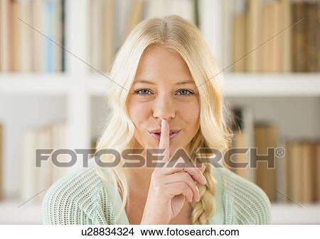 Picture - Portrait of woman with finger on lips. Fotosearch