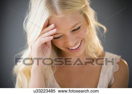 Stock Photography - Portrait of young woman braiding hair. Fotosearch