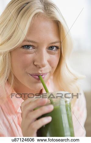 Portrait of young woman drinking smoothie View Large Photo Image Stock Photograph - Portrait of young woman drinking smoothie. Fotosearch