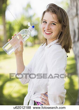 Portrait of young woman drinking water View Large Photo Image Stock Photo - Portrait of young woman drinking water. Fotosearch