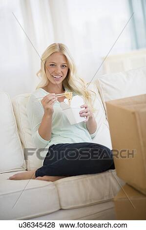 Stock Photo - Portrait of young woman eating Chinese food . Fotosearch