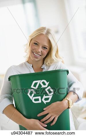 Portrait of young woman holding recycling bin View Large Photo Image Stock Photo - Portrait of young woman holding recycling bin. Fotosearch