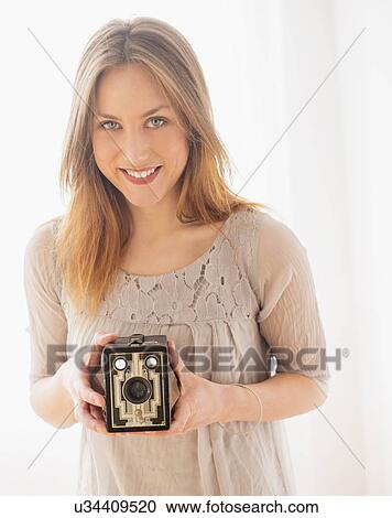 Portrait of young woman holding vintage camera View Large Photo Image Stock Image - Portrait of young woman holding vintage camera. Fotosearch