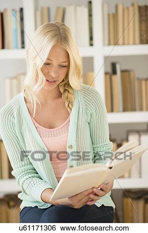 Portrait of young woman reading in library View Large Photo Image Stock Photograph - Portrait of young woman reading in library. Fotosearch