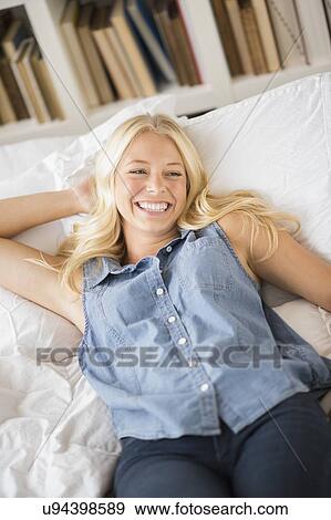Stock Photo - Portrait of young woman relaxing in bedroom. Fotosearch