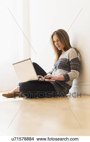 Picture - Portrait of young woman using laptop. Fotosearch