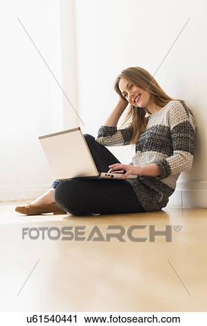 Portrait of young woman using laptop View Large Photo Image Stock Image - Portrait of young woman using laptop. Fotosearch