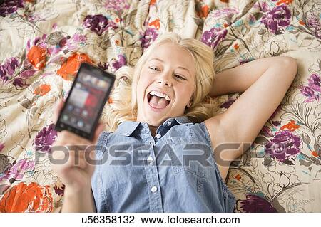 Portrait of young woman using mobile phone View Large Photo Image Stock Image - Portrait of young woman using mobile phone. Fotosearch
