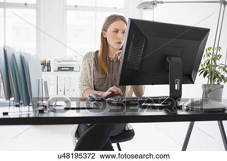 Portrait of young woman working on computer in office View Large Photo Image Stock Image - Portrait of young woman working on computer in office. Fotosearch