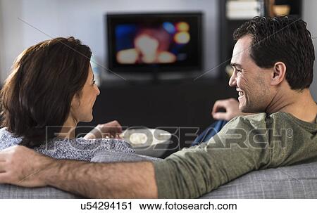 Rear view of couple watching tv View Large Photo Image Stock Image - Rear view of couple watching tv. Fotosearch