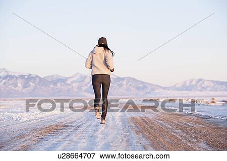 Rear view of woman running in winter landscape View Large Photo Image Stock Photo - Rear view of woman running in winter landscape. Fotosearch
