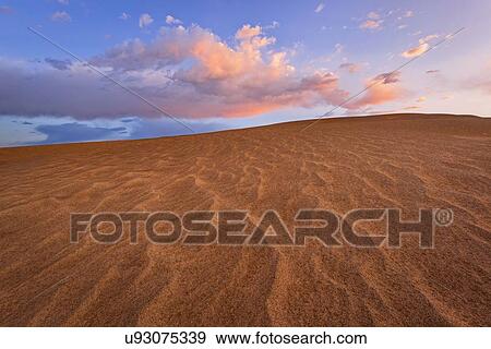 Sand dune and clouds during sunset View Large Photo Image Stock Photo - Sand dune and clouds during sunset. Fotosearch