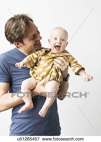 Stock Photo - Studio portrait of father with baby son (2-5 months). Fotosearch